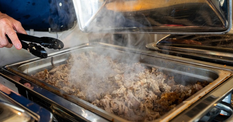 Smoking hot meat in a catering container