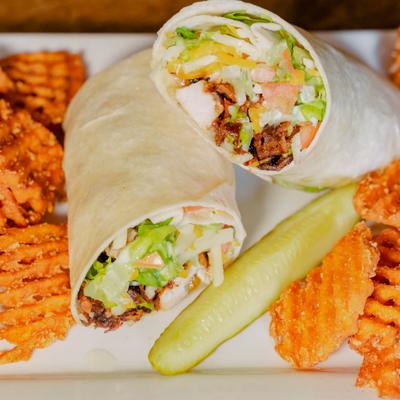 Grilled Chicken Bacon Ranch Wrap served with waffle fries and a pickle fries.