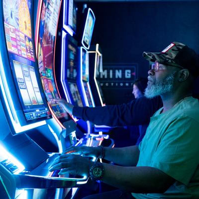 Several people playing slot machines.