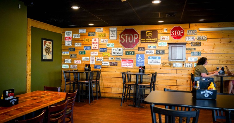 Interior, high tables and chairs near wall