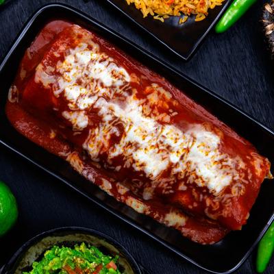 Burrito smothered in red salsa and cheese sauce.