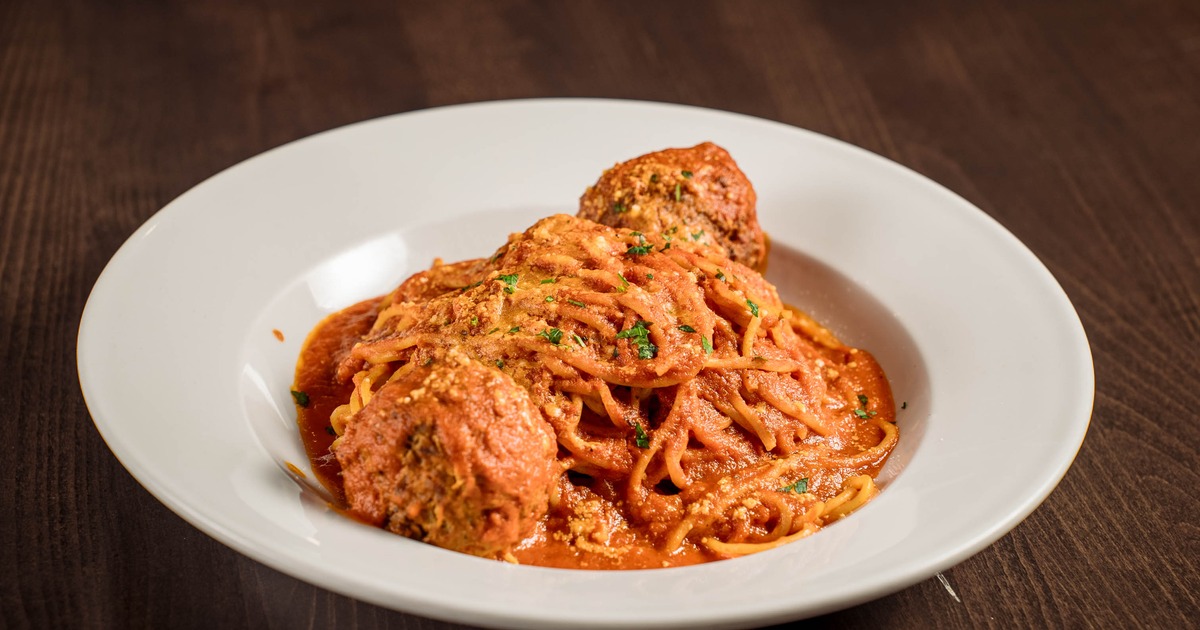Spaghetti with Meatballs topped with grated parmesan and herbs