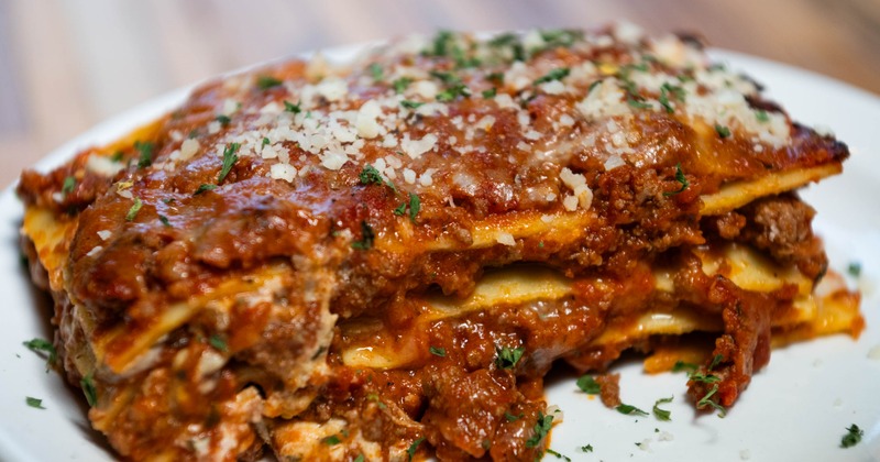 Lasagna topped with grated cheese and freah hrerbs, close-up