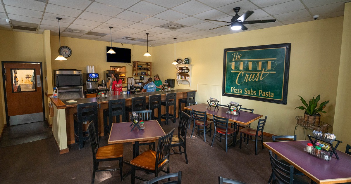 Cozy pizzeria interior with wooden tables and chairs, bar seating