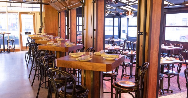 Interior, bar tables with tableware and stools