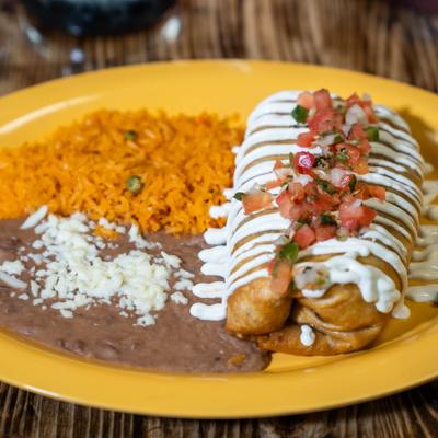 Chimichanga topped with sour cream and tomato salsa, served with rice and beans.