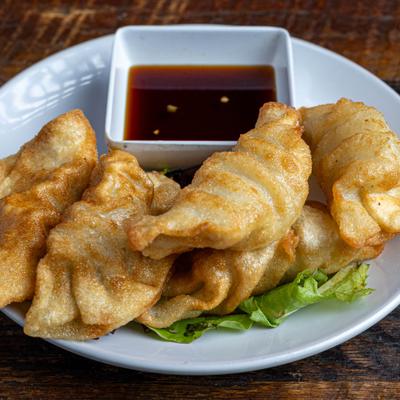 Pork Potstickers served with a dopping sauce.