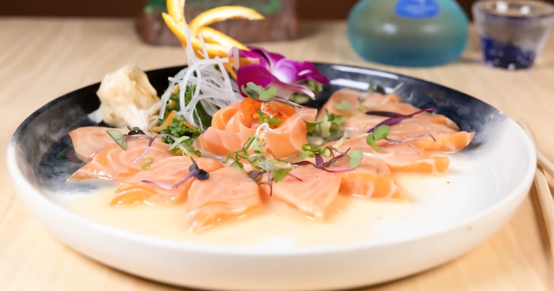 Salmon Sashimi arranged in a floral pattern and served in a yuzu-ponzu dressing