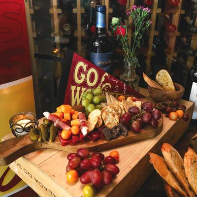 Charcuterie board with grapes, cheeses, crackers, meats and chocolate