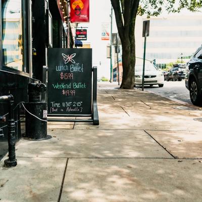 Exterior, restaurant's chalkboard on the sidewalk in front.