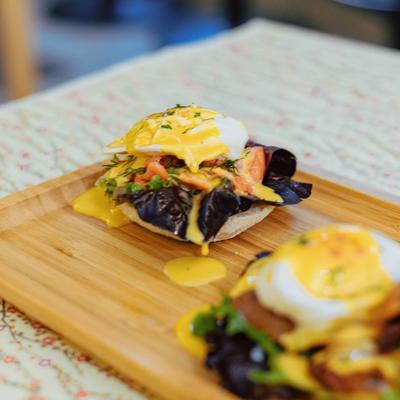 Eggs Benedict, with lettuce, bacon, tomato, poached eggs, and bechamel sauce.