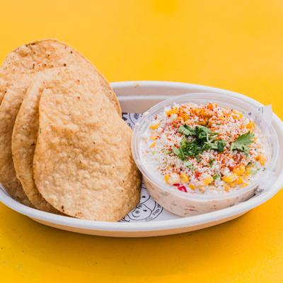 Queso fundido served on a plate with tortillas on the side.