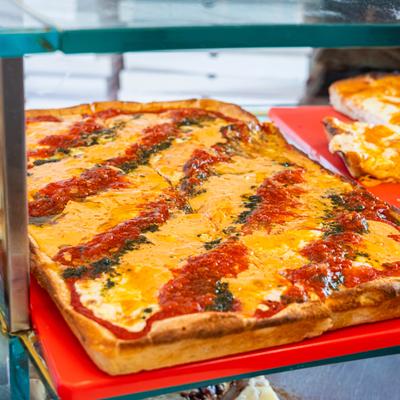 Pizza by the slice in a display case.