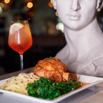 Osso Buco with broccolini and linguine pasta, accompanied with Aperol Spritz.