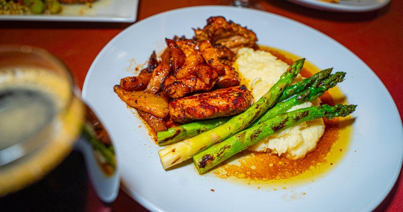 A meal of grilled pork chop with asparagus and mashed potatoes