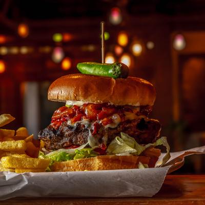 Hamburger served with fries, side view.