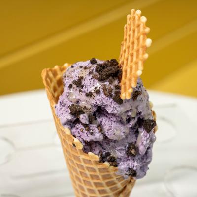 Blueberry lavender ice cream in a waffle cone with crumbled cookie topping.