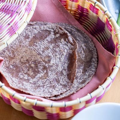 Blue corn tortillas in a woven basket.