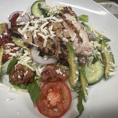 Grilled chicken salad with avocado, bacon, and cheese.