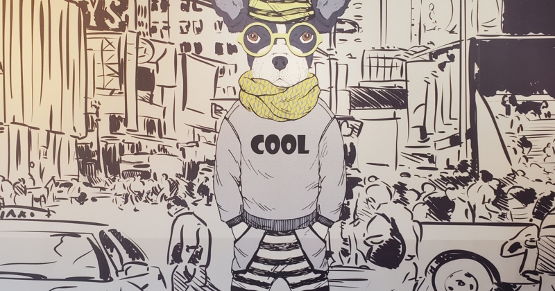 A wall mural featuring a stylized illustration of a hipster dog in a city scene