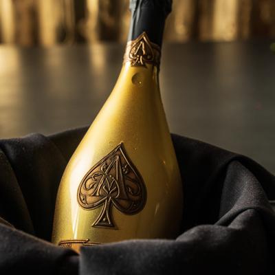 Gold champagne bottle in a black cloth-lined bucket.
