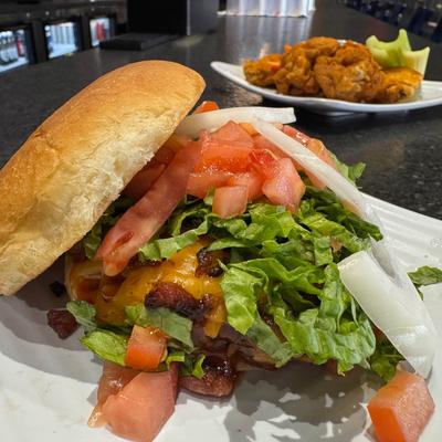 Cheeseburger with lettuce, tomatoes, onions, and cheddar cheese served with buffalo wings.
