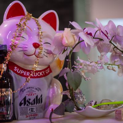 Lucky cat figurine beside flower decorations.