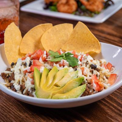 A southwest chorizo bowl served with avocado and chips.