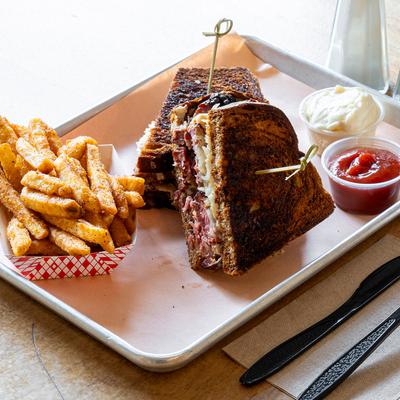 Smoky Reuben served with fries and sauces.