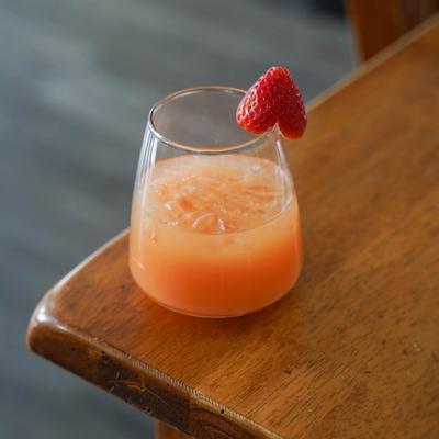A cocktail garnished with a strawberry.