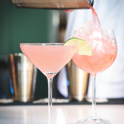 Cosmopolitan cocktail being poured into a glass.