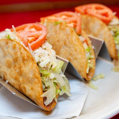 Chicken tacos, with lettuce, tomato, and cheese.