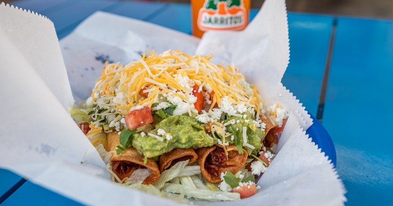 Flautas, with guacamole, lettuce, tomato, sour cream, and cheese