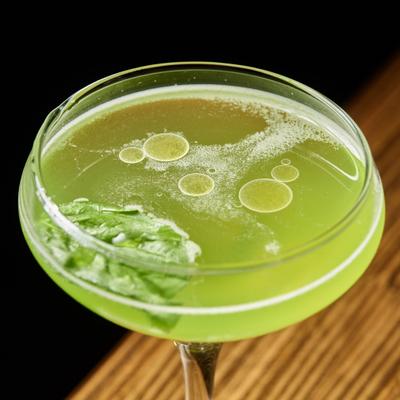 The Lodger, Green cocktail with basil leaf and oil droplets on top.