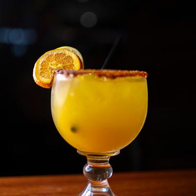 Mango Flavored Orange colored frozen Margarita rimmed with tajin.