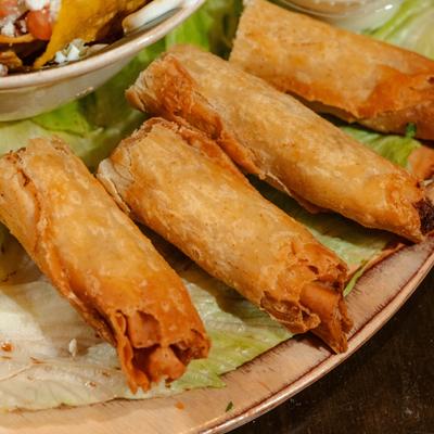 Chicken rolled taquitos served over lettuce as a part of Sampler Plater.