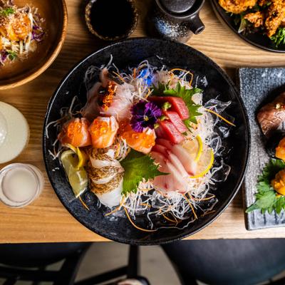 Assorted sashimi platter with salmon, tuna, roe, and flower garnish.