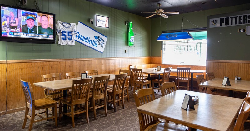 Interior, a room featuring wooden tables and chairs, TV and wall decorations