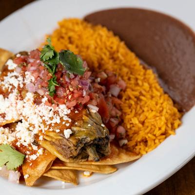 Stuffed Poblano Peppers. topped with salsa, and served with rice, and beans.