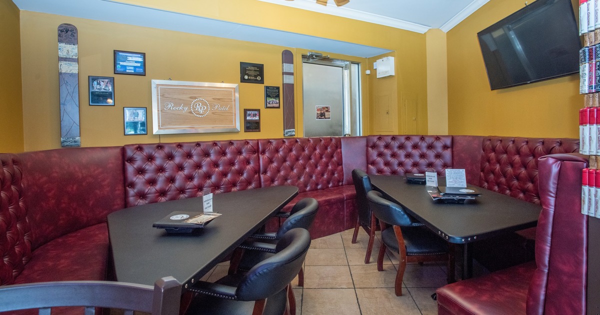 Interior featuring deep red, button-tufted leather booth seating arranged along the walls