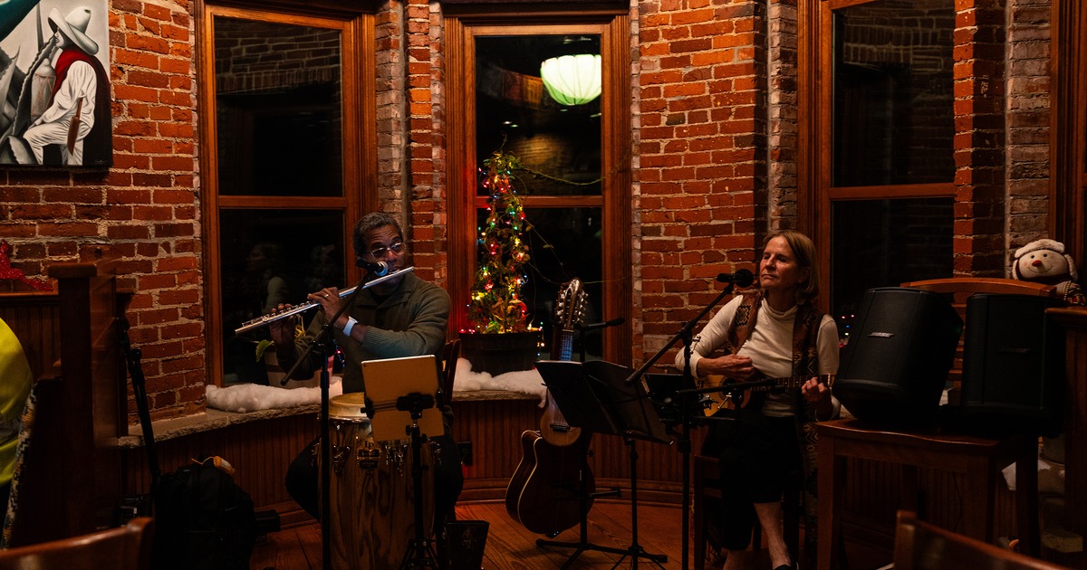 Two musicians playing the flute and guitar