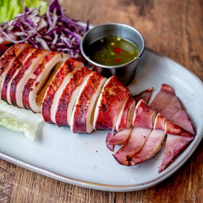 Grilled squid served with lettuce, shreded cabbage and a dipping sauce.