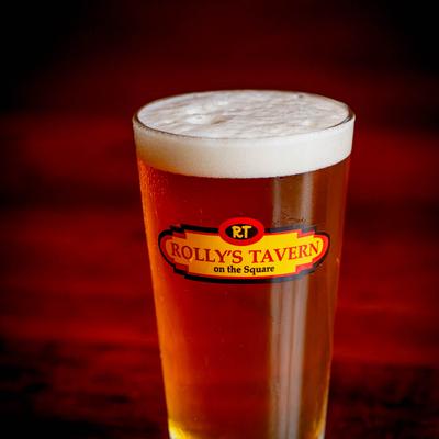 Beer served in Rolly's Tavern glass on a wooden surface.