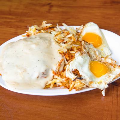 Country fried steak served with hash browns and fried eggs.