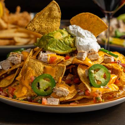 Loaded nachos with cheese, chicken, jalapenos, guacamole, and sour cream.