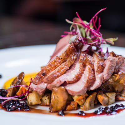 Dish of duck breast with micro greens and vegetables