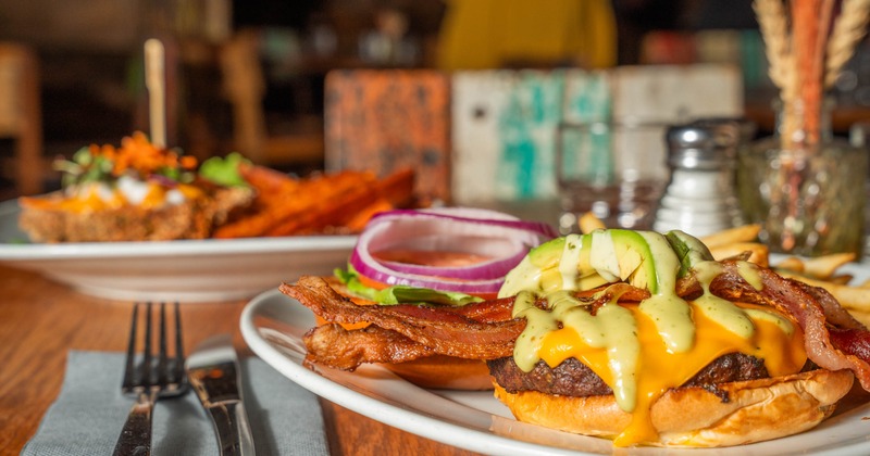 Photo of a burger with a help wanted ad for host and line cook.