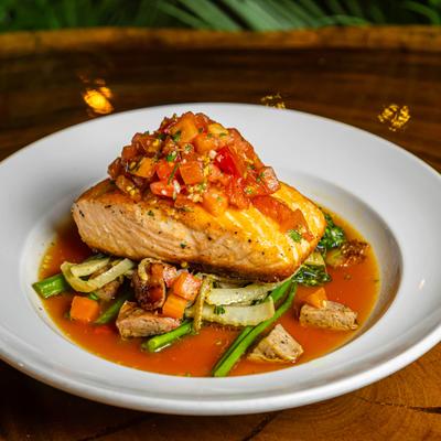Faroe Island Salmon topped with tomato salsa, served over sauteed greens and vegetables.