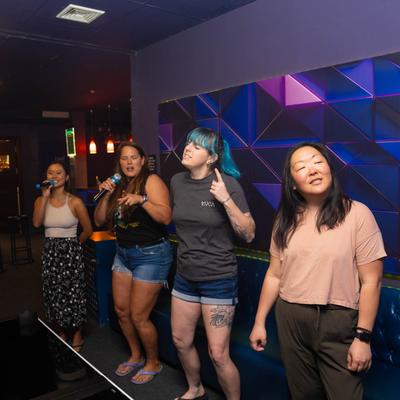 Four people enjoying themselves, with two holding microphones.