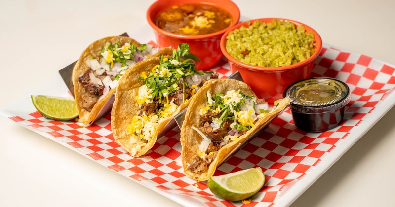 Street tacos served with green rice and refried beans